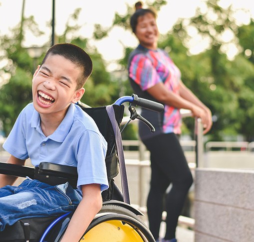 a young boy in a wheelchair smiling 