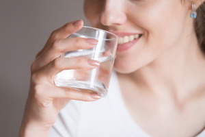 Woman in white shirt about to take sip of water