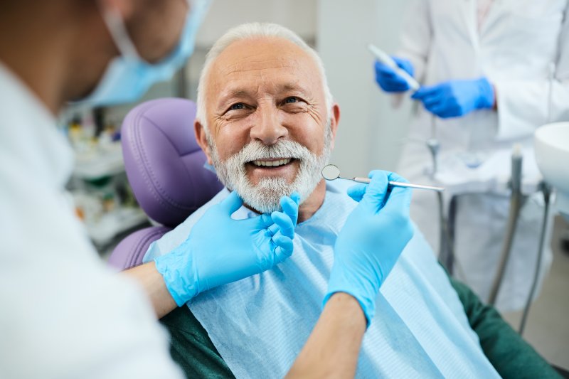 a patient smiling at his dentist after dental care